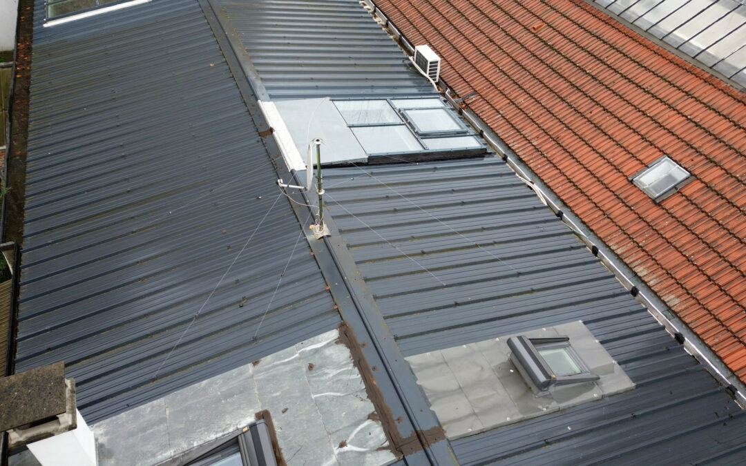 Vue aérienne d’une toiture en bac acier avec fenêtres de toit.